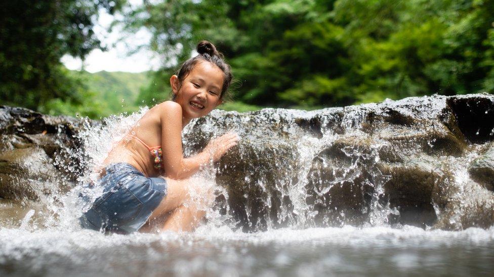 girl-playing-in-waterfall