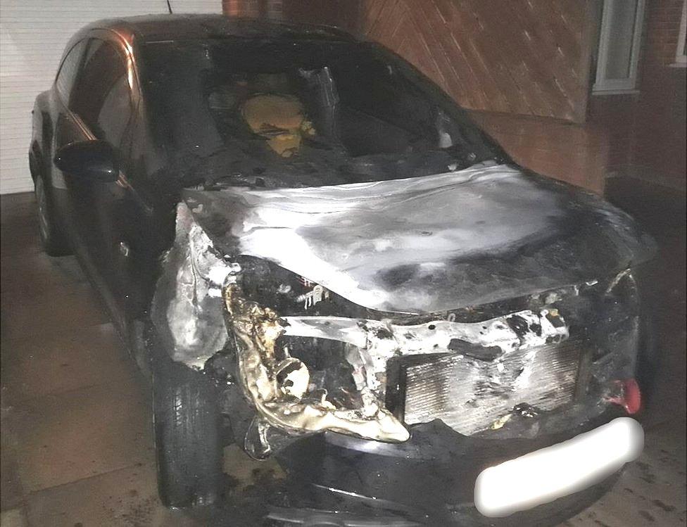 Fire-damaged car on drive