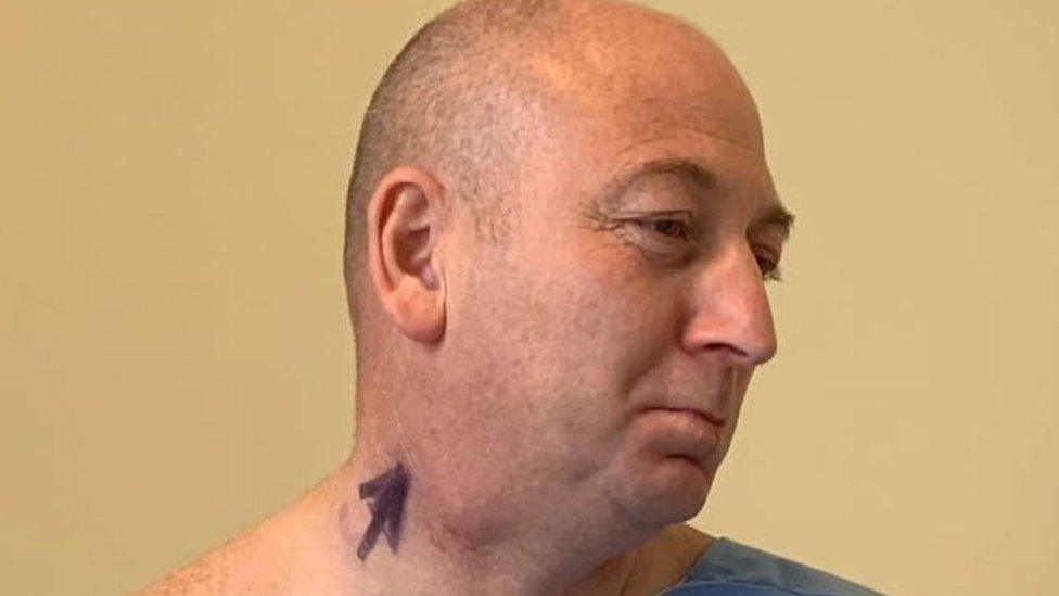 Martin before the operation with an arrow written on his neck next to a visible lump