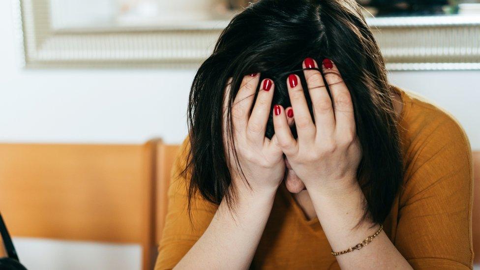 A stock image of a woman head in hands