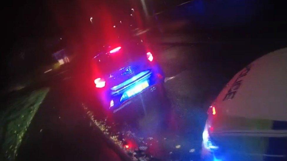 A car pulled over by police in the dark