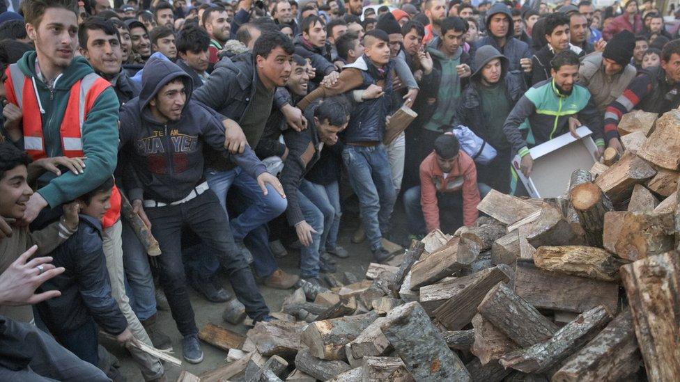 Migrants mob a truck bringing donated firewood at the northern Greek border station of Idomeni, ()6 March 2016)