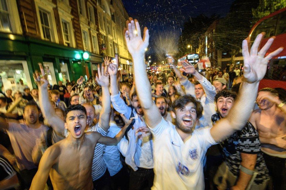 Football fans celebrate in a London street