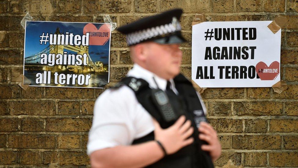 Policemen in front of "united against all terror" posters