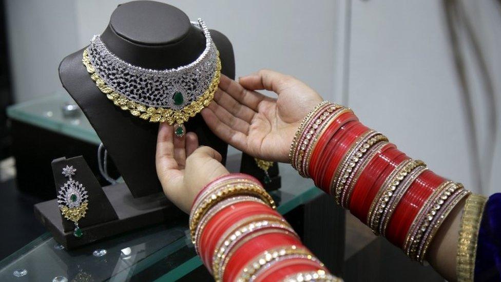 An Indian woman looks at gold jewellery at a shop on 09 November 2016.