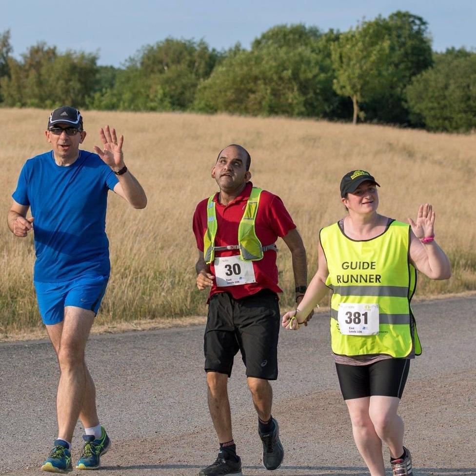 Sajid running with his guide runner and another runner