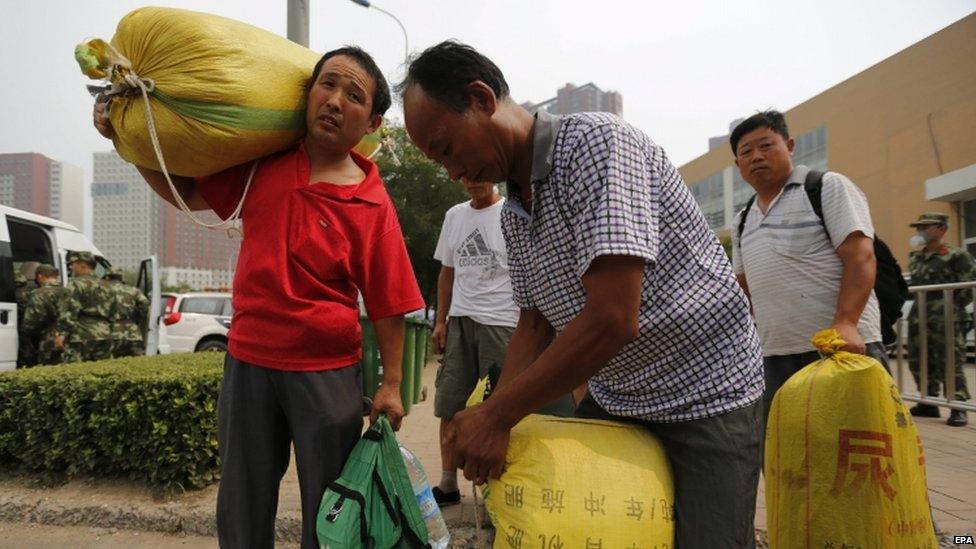 Evacuees carry luggage - 15 August