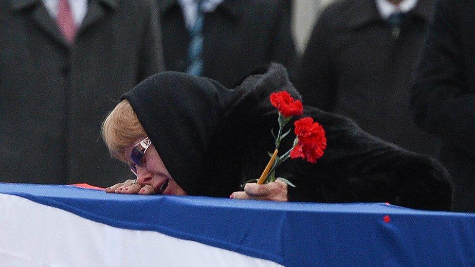 Marina Karlov mourns her husband laying her head on top a flag-wrapped coffin of late Russian Ambassador to Turkey Andrei Karlov before being carried to a plane by Turkish soldiers during a ceremony at Esenboga airport on December 20, 2016 in Ankara