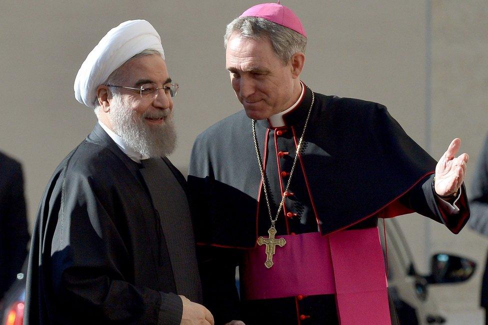 The prefect of the papal household bishop Georg Gaenswein (R) welcomes Iranian President Hassan Rouhani in Rome