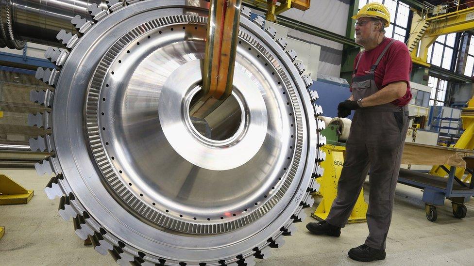 A worker assists in moving a disc of a gas turbine at the Siemens gas turbine plant