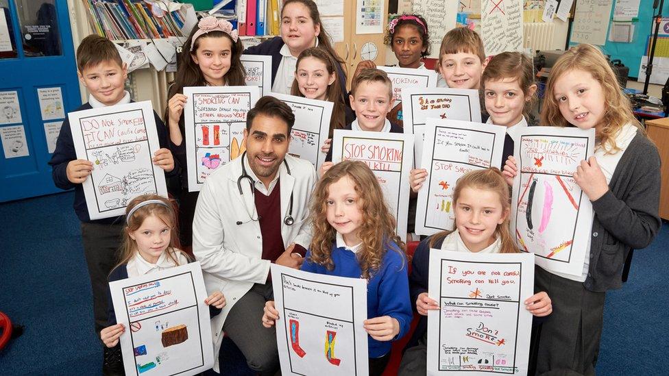 Children holding up anti-smoking packaging