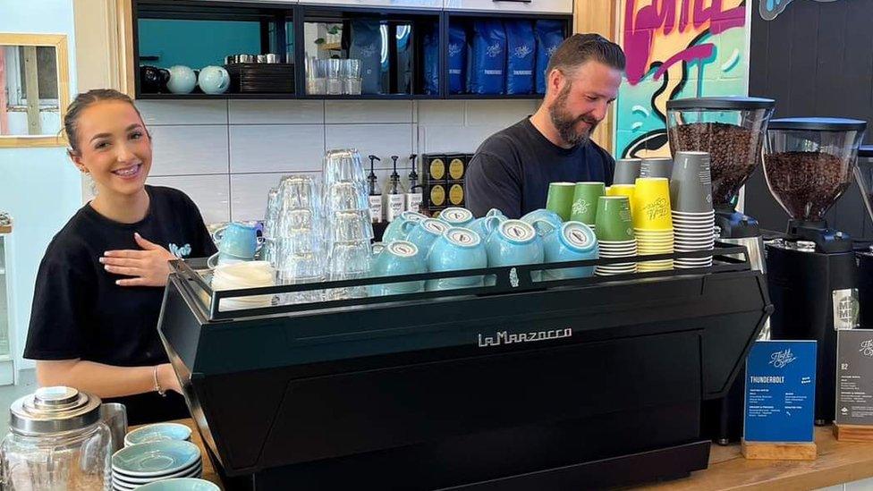 A young woman and a man work behind the coffee machine at Khaos Cakery in Auckland