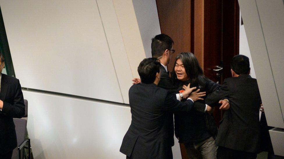 Leung Kwok-hung, Known as 'Long Hair' (R), is removed from the Legislative Council Chambers for interjecting during Chief Executive Leung Chun-ying 2016 Policy Address in the Admiralty district of Hong Kong on January 13, 2016