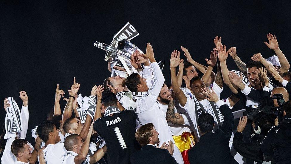 Real Madrid players celebrating with the Champions League trophy in May 2016