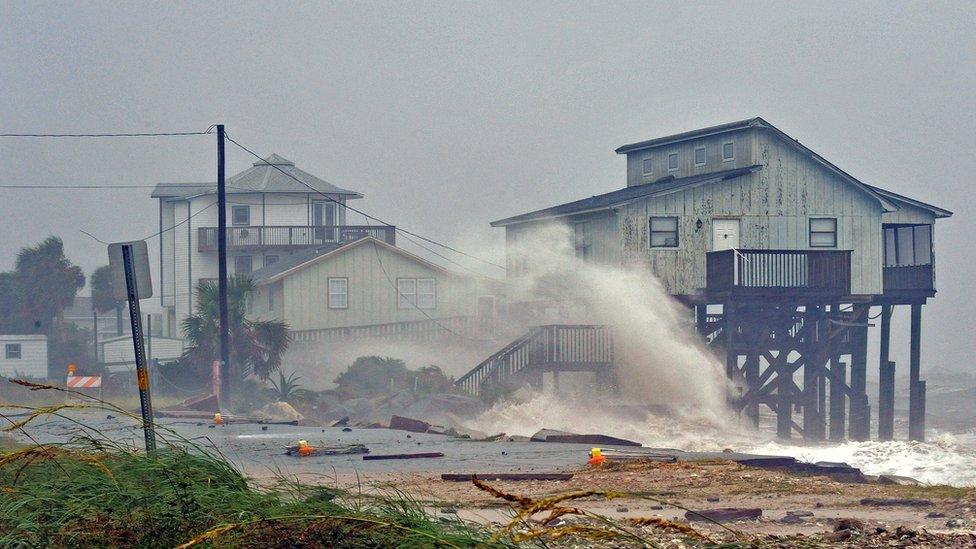 Waves crash into stilt houses along the shore at Alligator Point in Franklin County, Florida