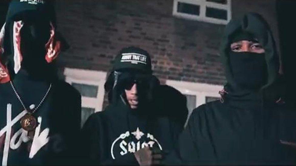 Isaac Marshall (right) and others in drill music video