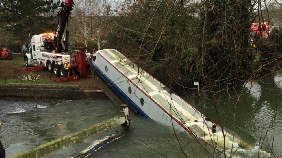 The Environment Agency using a winch attached to a crane to hoist the boat out of the water