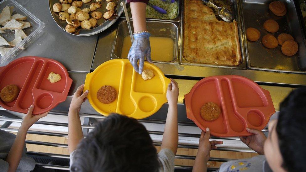 School children being served free meals at school