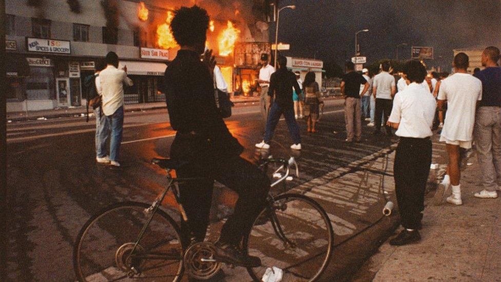 A view of businesses beginning to burn on Pico Boulevard near Hayworth Avenue during Rodney King riots in 1992