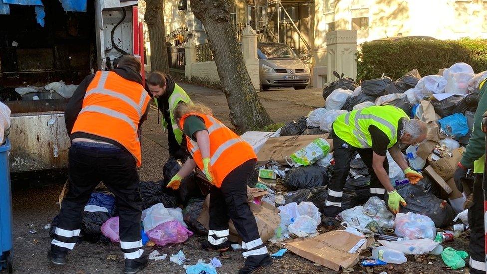 Refuse workers clear a street in Brighton