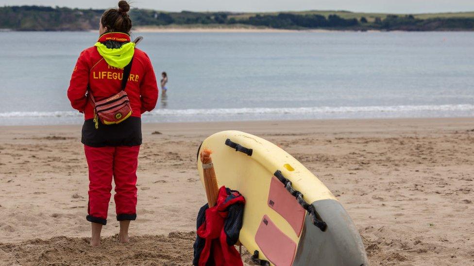 A general view a female RNLI Lifeguard working on South Beach in Tenby