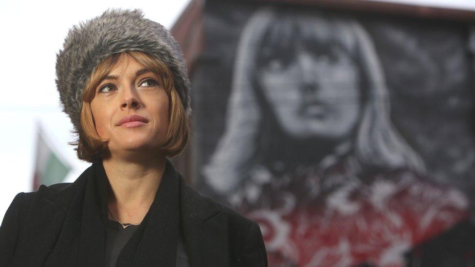 Gwenno Saunders alongside the mural featuring her face