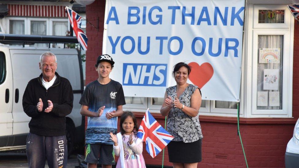 family-clapping-with-sign-in-the-background.