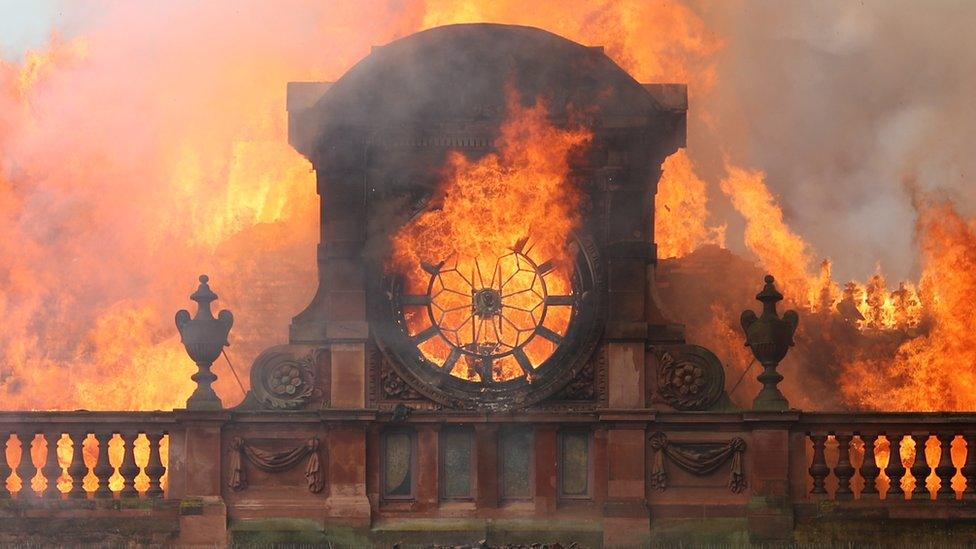 Flames destroy the clock at the top of Bank Buildings