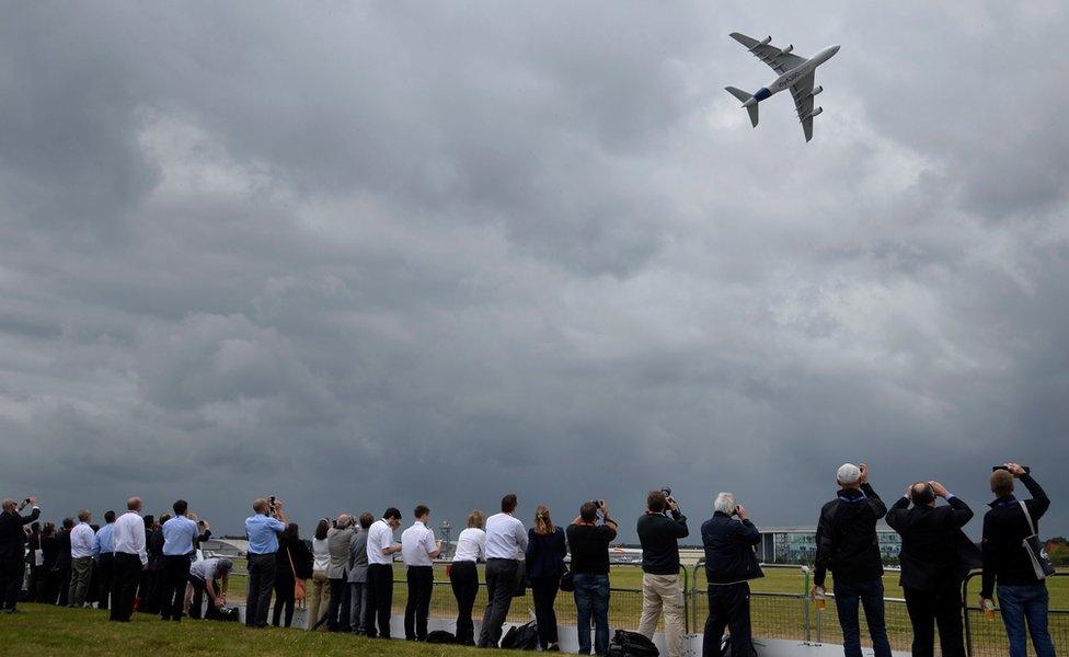 Plane enthusiasts watch an Airbus A380 during a flight demonstration