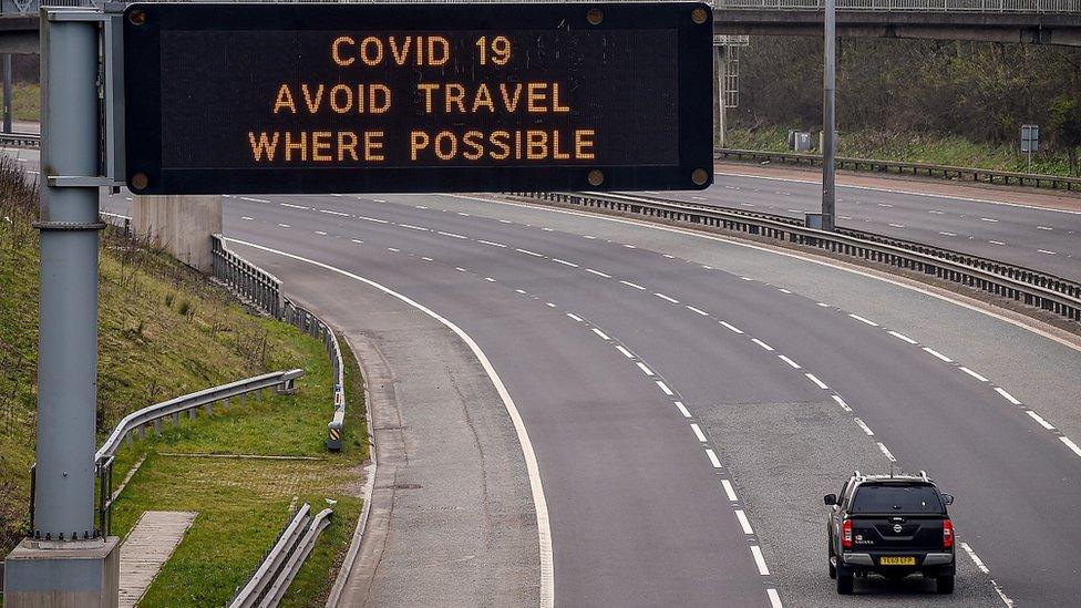 a road in Scotland with a Covid9 warning on a sign