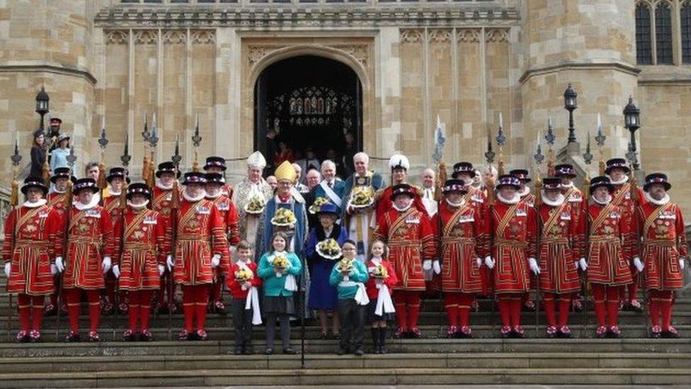 The Queen standing outside St George's Chapel alongside beefeaters