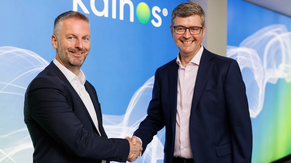 Russell Sloan and Brendan Mooney shaking hands in the Kainos boardroom