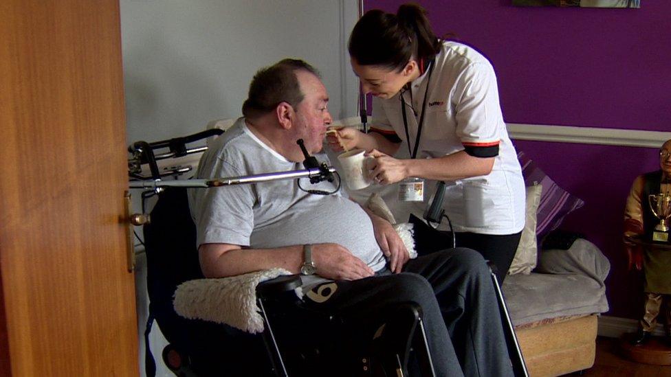 Carer Charlene McCoy gives a cup of tea to her patient Martin Harney