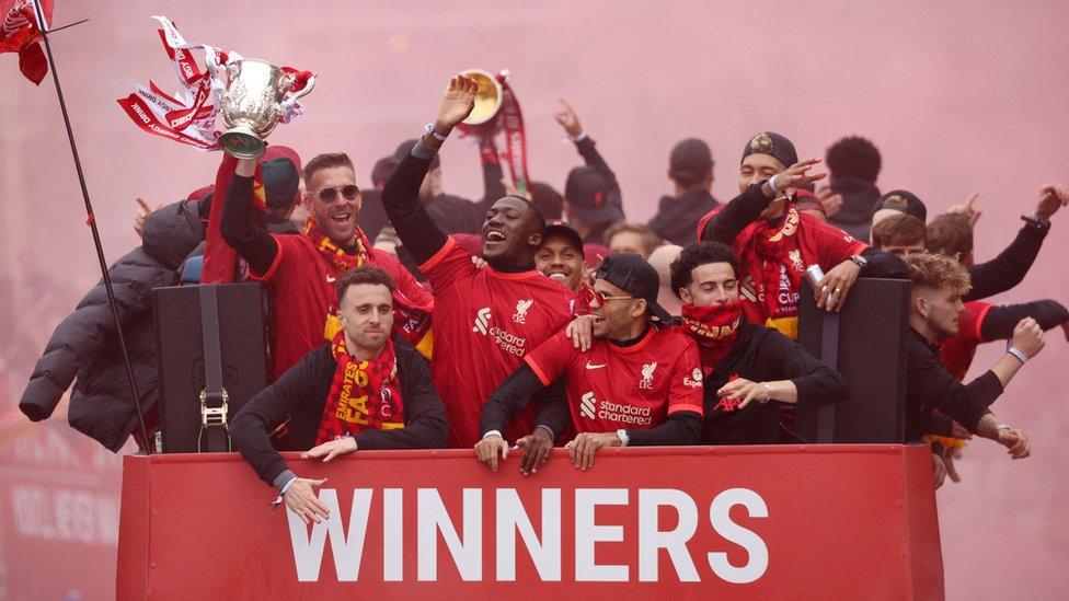 Adrian holds the Carabao Cup trophy as he celebrates with Diogo Jota, Ibrahima Konate, Luis Diaz, Curtis Jones, Roberto Firmino and teammates