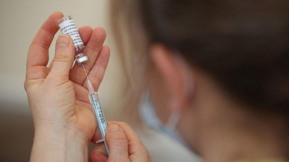 nurse preparing a Covid-19 vaccine