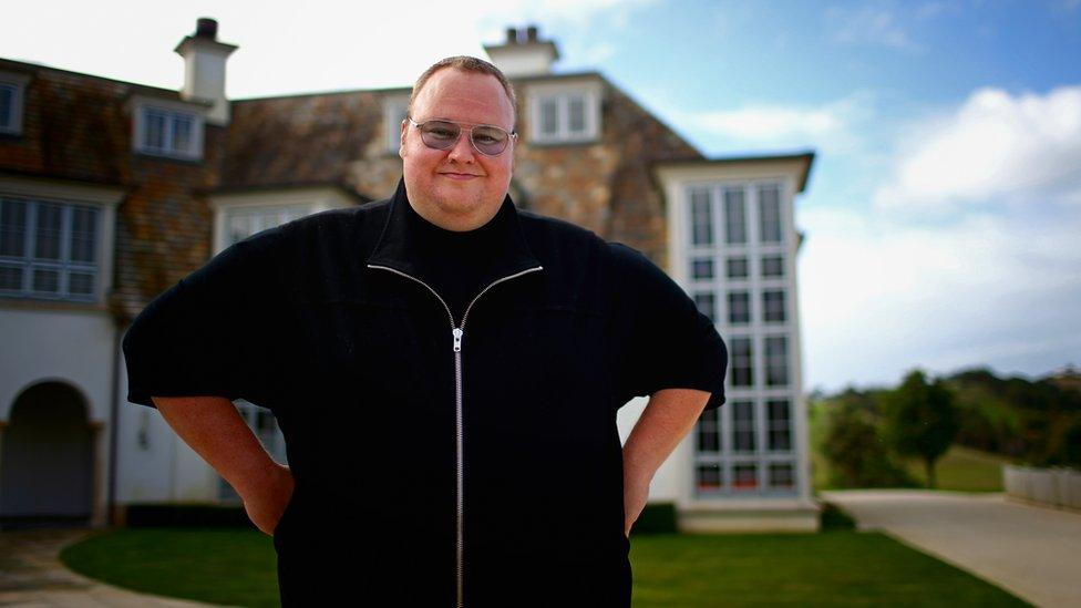 Kim Dotcom stands outside his mansion in New Zealand