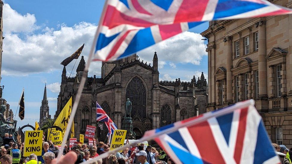 Union jack flags and 'Not my King' signs waving in Edinburgh