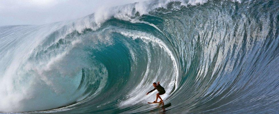 A surfer rides a wave at Teahupoo in Tahiti on May 14, 2013