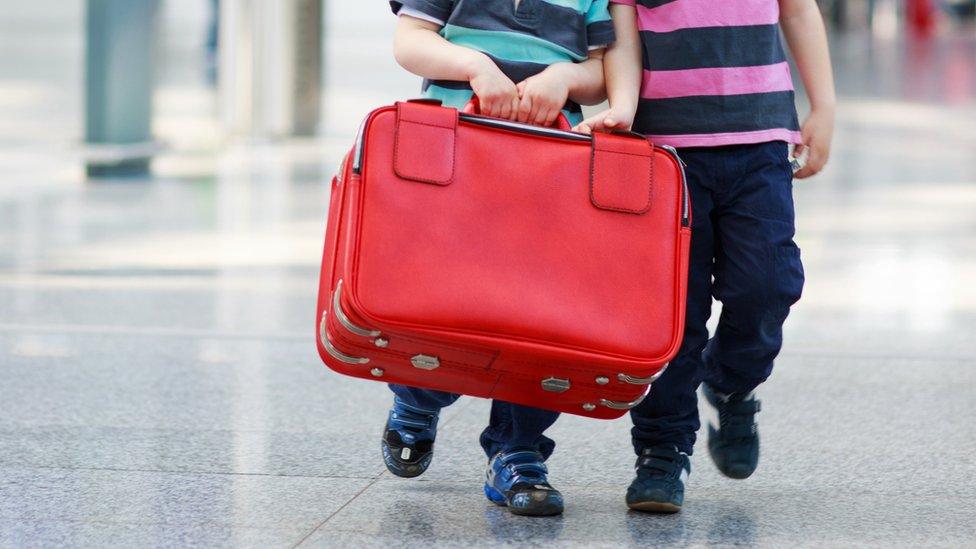 Boys carrying a suitcase