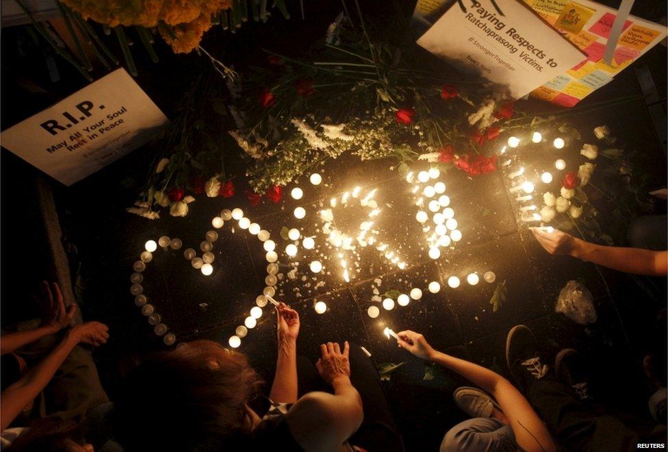 People light candles at the Erawan shrine, the site of Monday's deadly blast, in central Bangkok, Thailand, 18 August 2015.