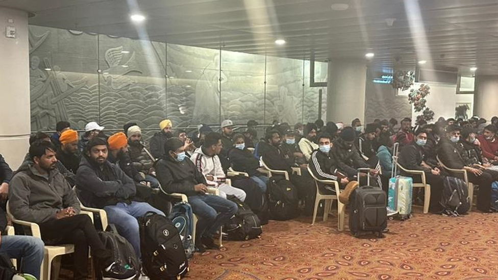 Indian passengers wait at the Mumbai airport after the plane finally lands there