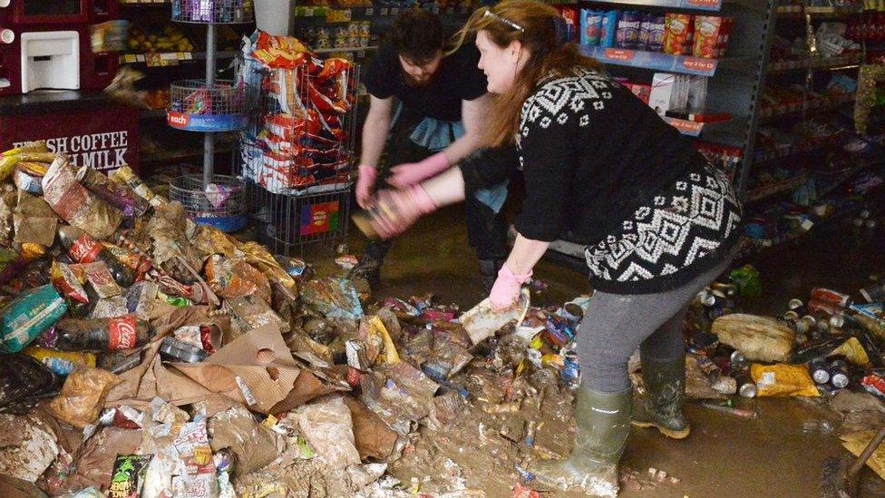 Shop workers clearing rubbish from a flooded store in Cockermouth in December, 2015