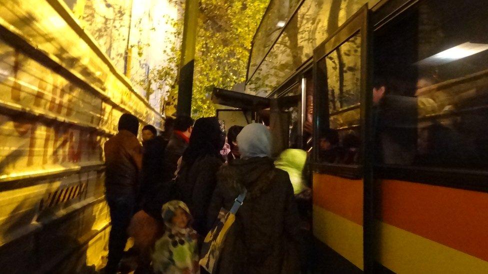 Refugees getting onto a bus in Athens