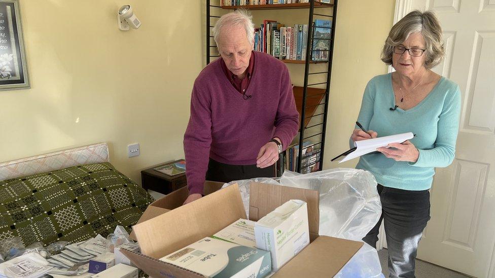 A woman and man looking at medical supplies