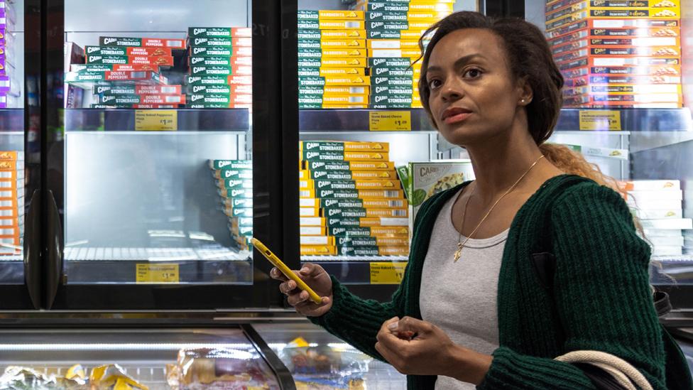 Woman next to a supermarket freezer