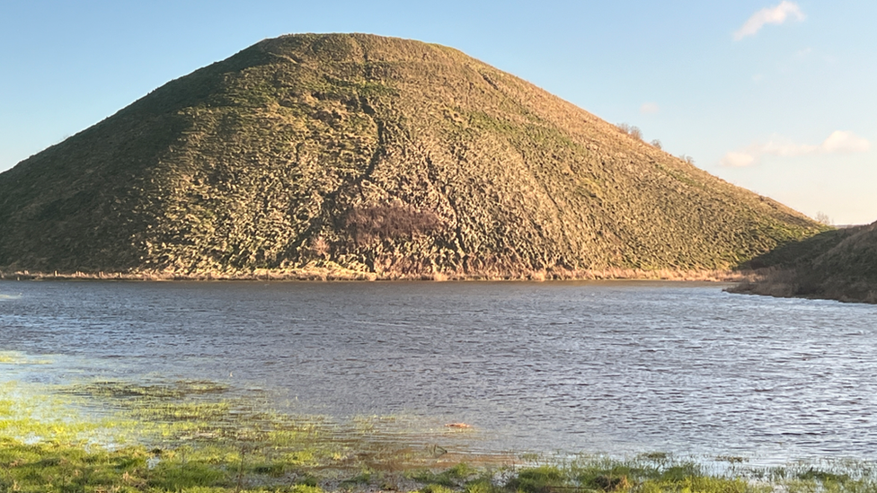 Ancient Wiltshire monument by Avebury, Silbury Hill, surrounded by flood water