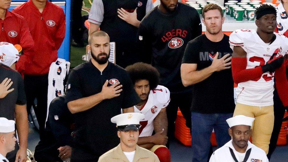 San Francisco 49ers quarterback Colin Kaepernick, middle, kneels during the national anthem before the team's NFL preseason football game against the San Diego Chargers, Thursday, Sept. 1, 2016, in San Diego