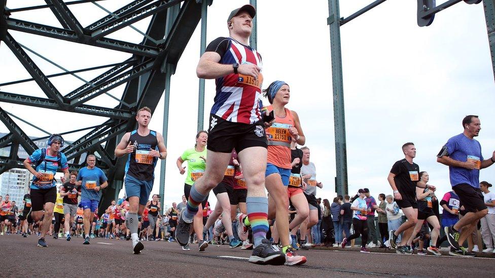 Runners including a man in a Union Jack shirt cross the Tyne Bridge