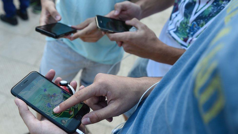 A close-up of people playing Pokemon Go on their smartphones