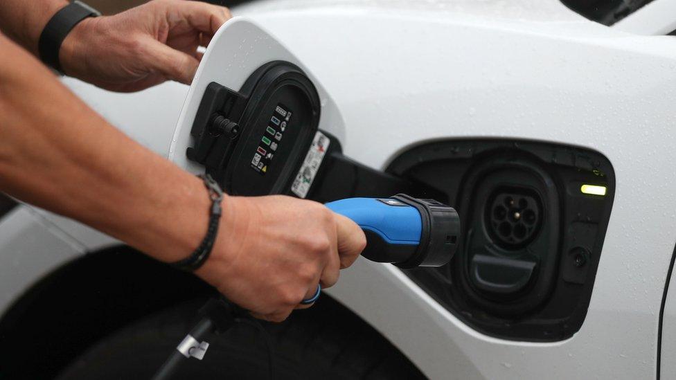 A man charges an electric car